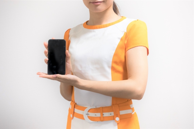 スマホを持つ女性コンパニオン