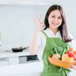 笑顔のオーガニック野菜を抱く女性