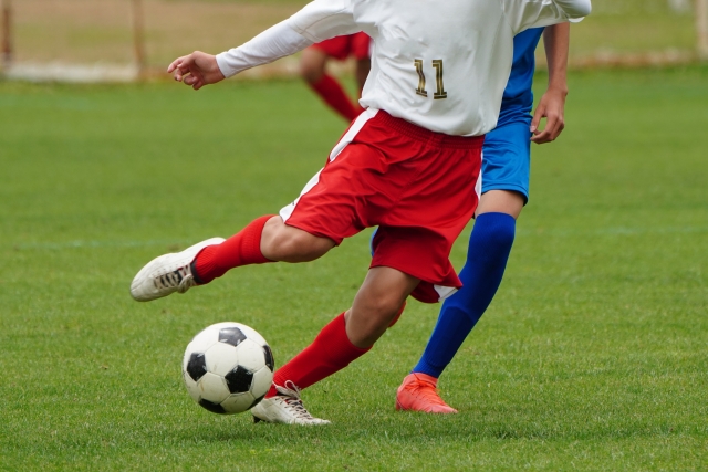 サッカーボールを蹴る人